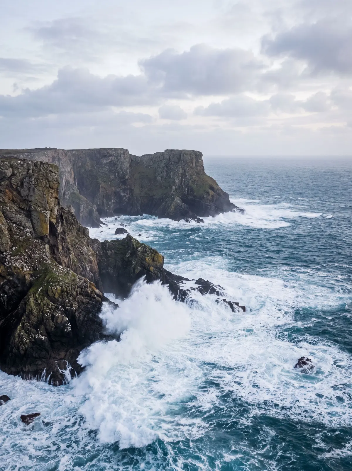Dramatic ocean cliffs with crashing waves under an overcast sky, generated with Nano Banana
